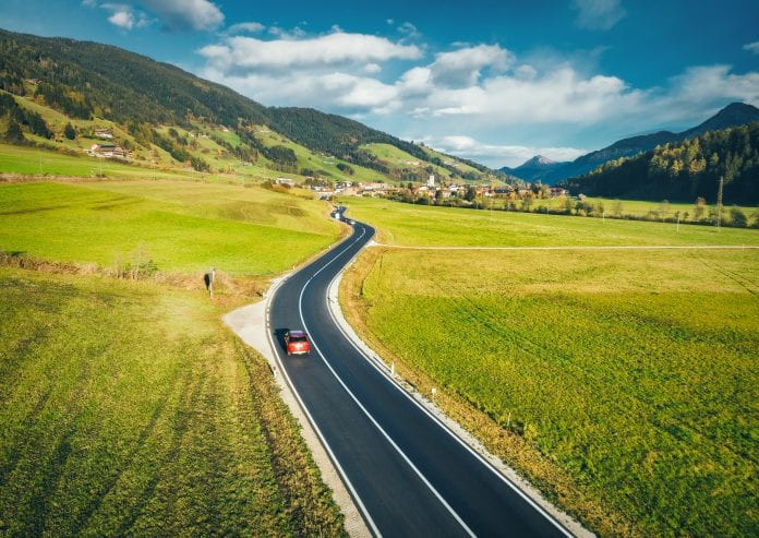 Aerial view of the road in mountain valley at sunset in spring