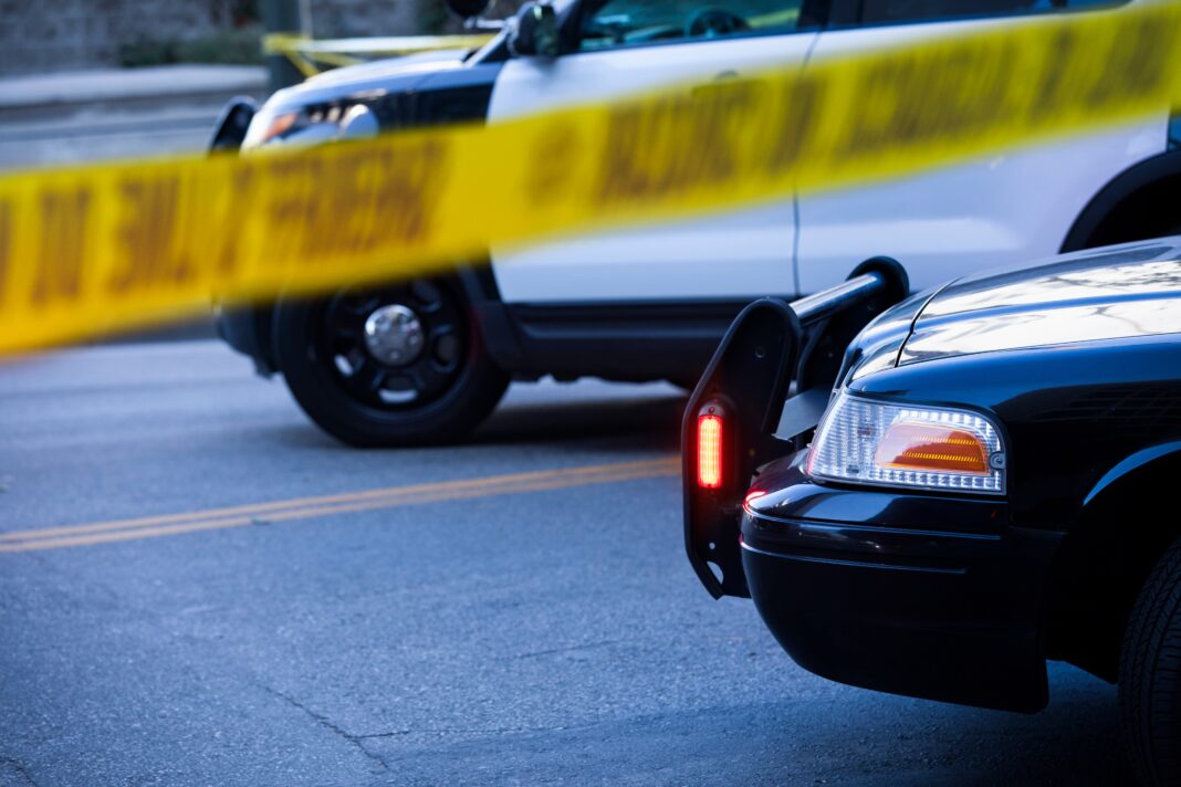 Police tape and barricade crime scene with cars after incident