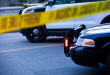 Police tape and barricade crime scene with cars after incident