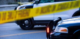 Police tape and barricade crime scene with cars after incident