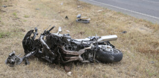 Crashed motorcycle scattered on side of road