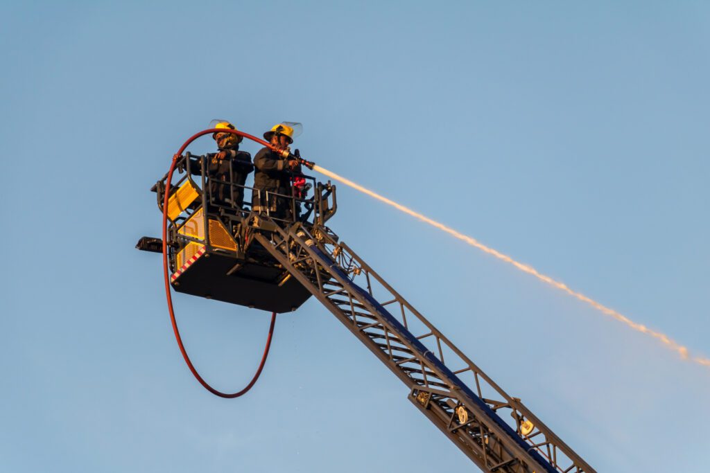 Elevated fire fighting crew extinguishing fire on crane 