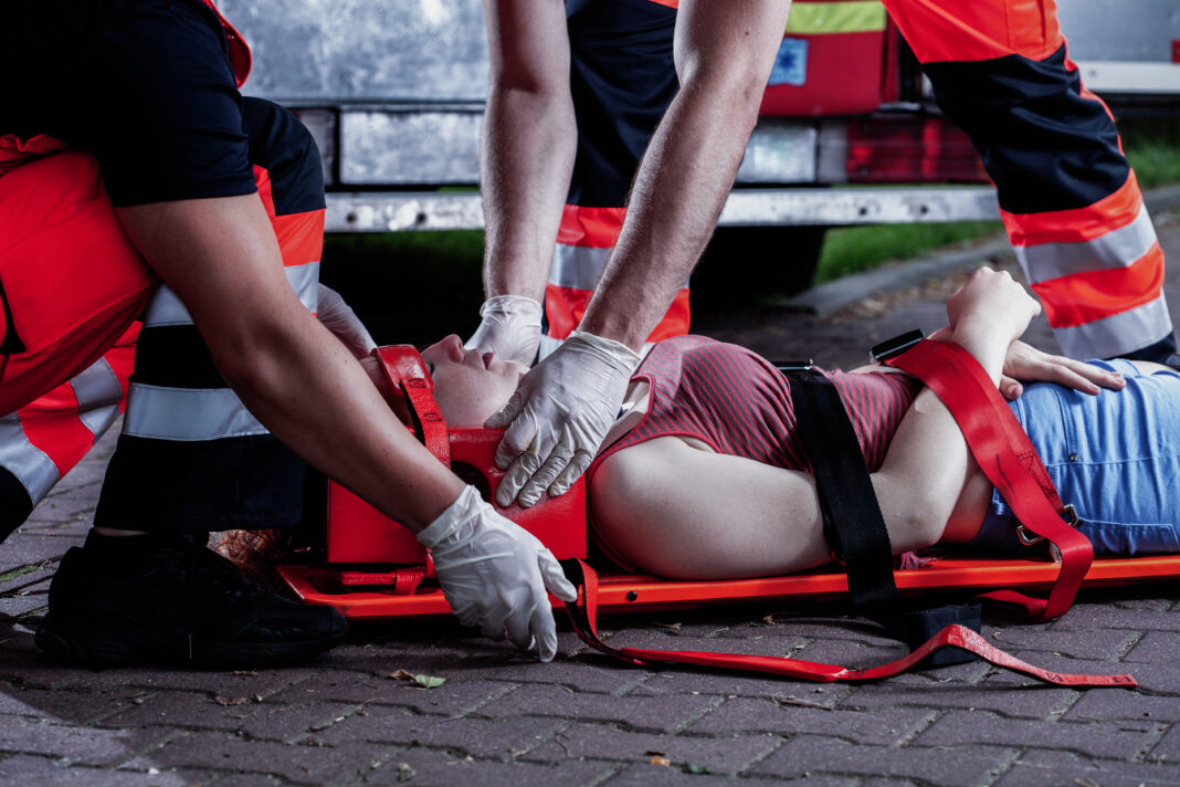 Medic bending over car accident victim