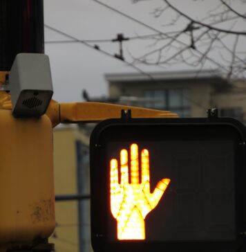 Pedestrian cross light reflecting out onto road