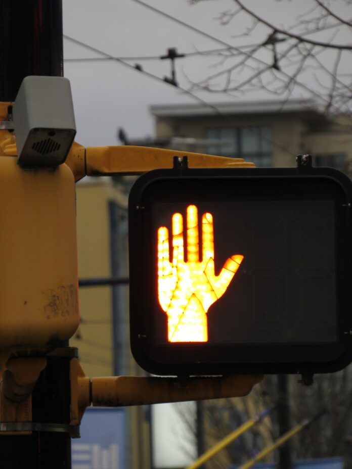 Pedestrian cross light reflecting out onto road