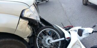 Crashed motorcycle on ground following car accident