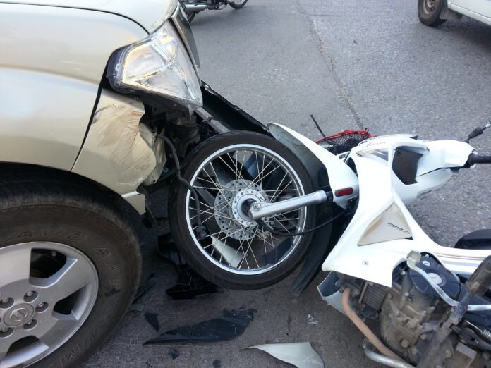 Crashed motorcycle on ground following car accident