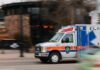 red white and blue ambulance driving to scene of emergency