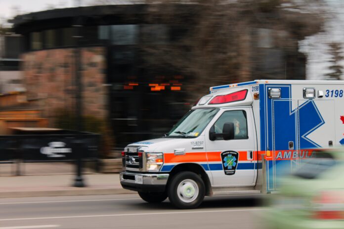 red white and blue ambulance driving to scene of emergency
