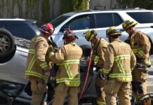 Emergency personnel assist victims trapped in vehicle following accident