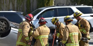 Emergency personnel assist victims trapped in vehicle following accident