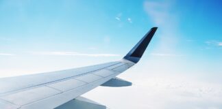Wing of business jet depicted while flying in air