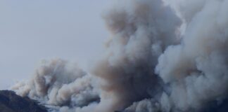 large wildfire smoke clouds depicted in the distance