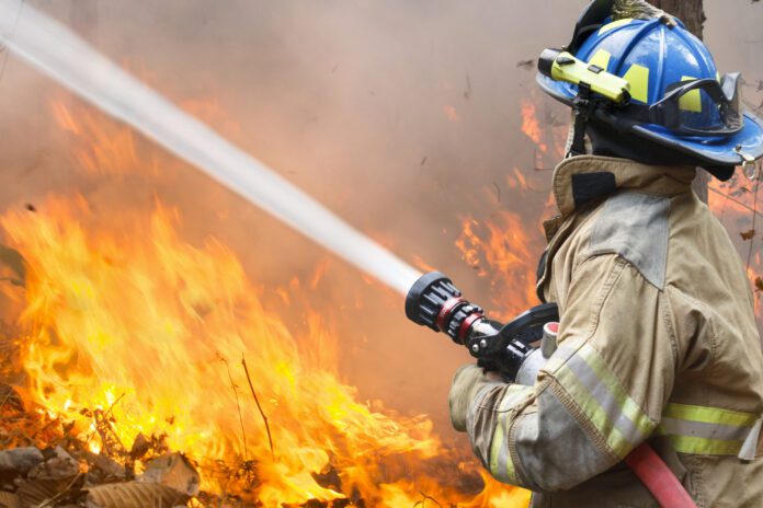firefighter attempting to put out large blaze is depicted