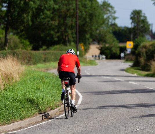 bicyclist depicted riding bicycle on road