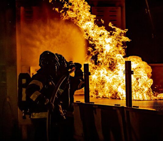 firefighters attempting to put out large Apartment fire